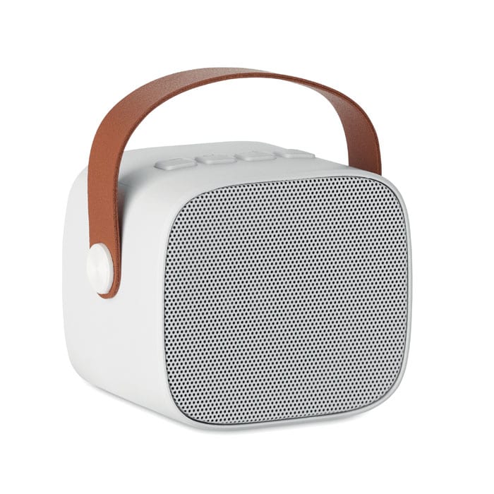 A portable speaker in white with a textured front grille and a brown leather carry strap.