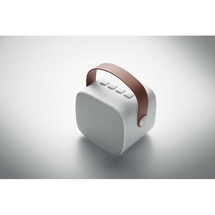 A portable speaker in white with a brown leather handle, featuring control buttons on the top.