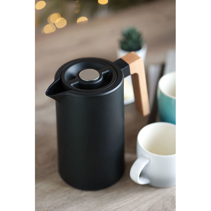 A drink bottle in matte black with a wooden handle, positioned beside two mugs on a wooden surface.