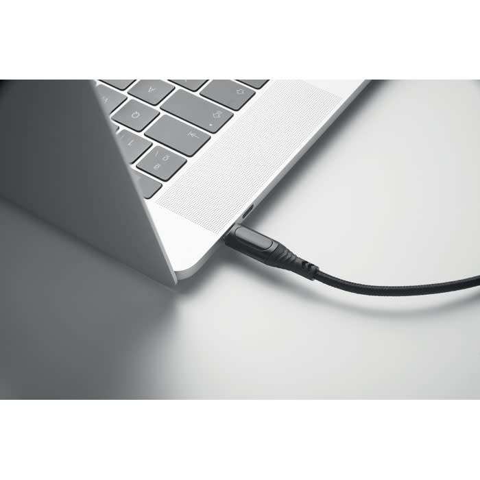 A laptop with a black cable connected to its side, featuring a sleek silver design.