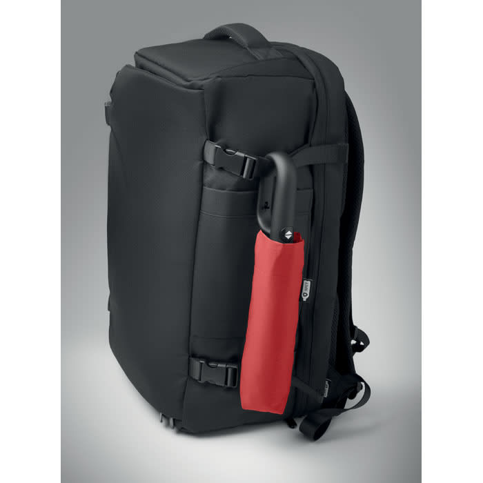 A black backpack with a red umbrella attached to its side, featuring adjustable straps and multiple compartments.