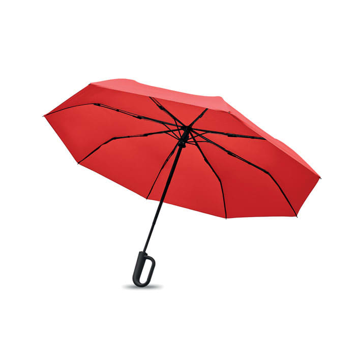 A red umbrella with a black handle, featuring multiple ribs for support and a curved shape.