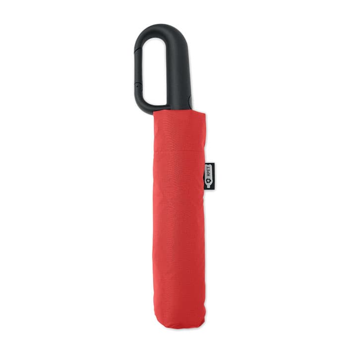 A compact red umbrella with a black handle, stored in a matching red sleeve, featuring a branding tag.