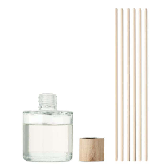 A glass bottle with a wooden cap and six bamboo sticks beside it, containing a clear liquid.