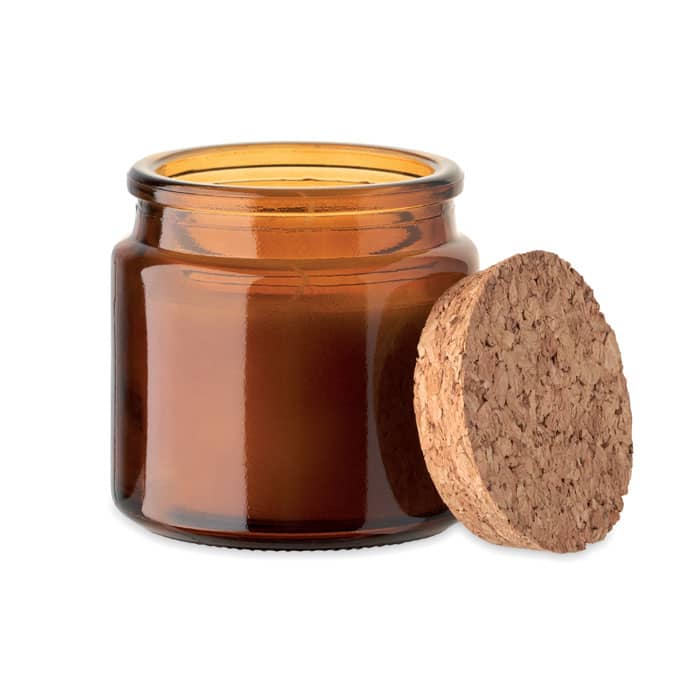 A glass jar in amber colour with a cork lid, standing open on a white surface.