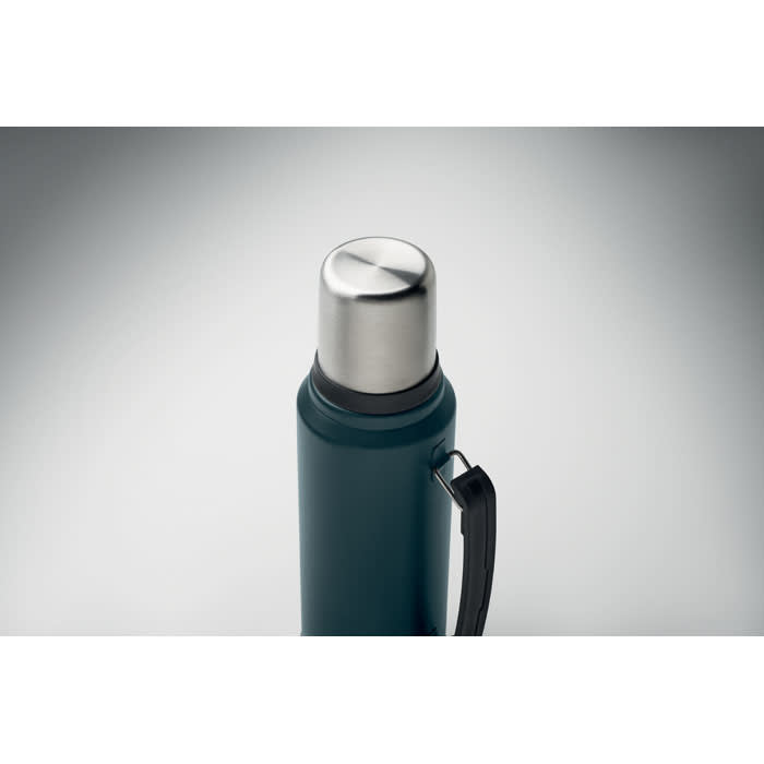 A drink bottle in dark teal with a silver stainless steel lid and a side handle. It has a branded logo.
