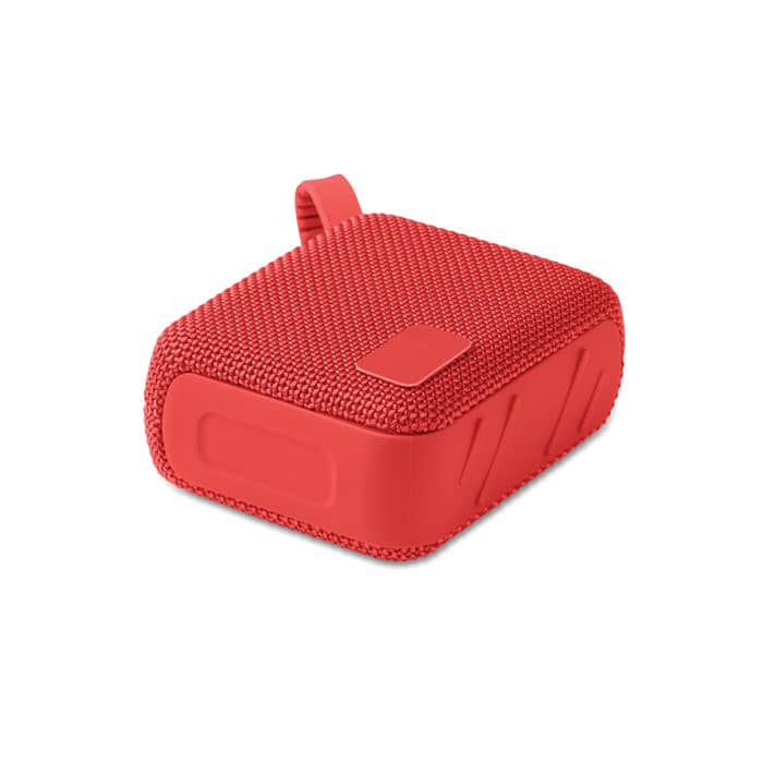 A red square speaker with a textured surface and a small loop for carrying. The product features a logo on the side.