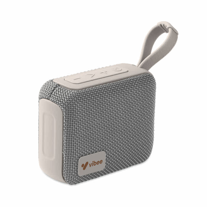 A portable speaker with a grey fabric exterior, featuring controls on the top and a strap for easy carrying.