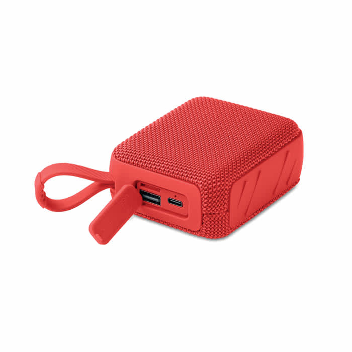 A red portable speaker with a textured exterior and a USB-C port, featuring a convenient attachment loop.