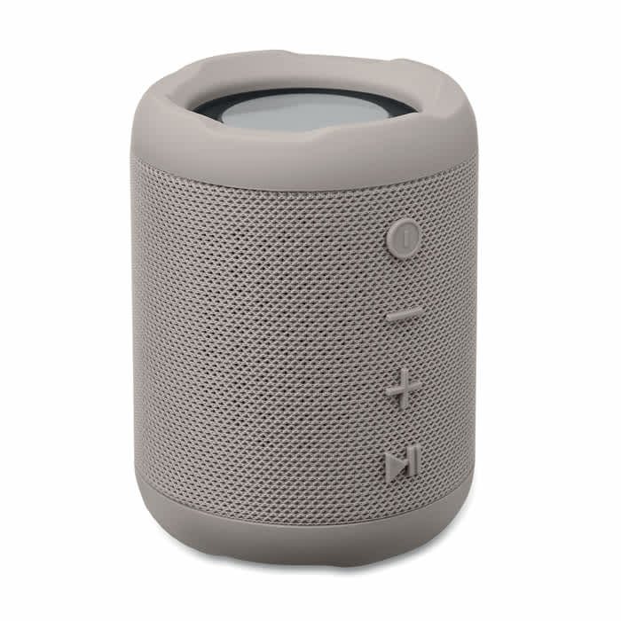 A portable speaker in a light grey colour with control buttons and a textured design. It features a manufacturer's logo.