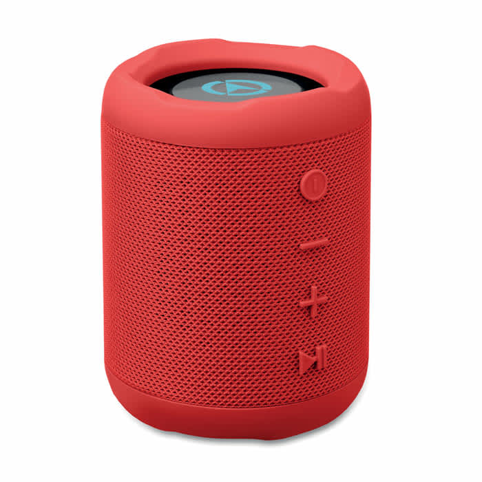 A portable speaker in vibrant red with a mesh exterior and control buttons on the side. It features a logo on top.