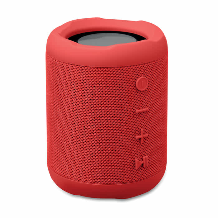 A red portable speaker with a textured surface and control buttons on the side. The speaker features a rounded design.