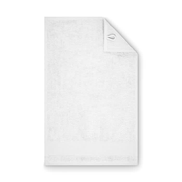 A white towel with a corner tag and loop for hanging. It has a textured surface and a plain design.