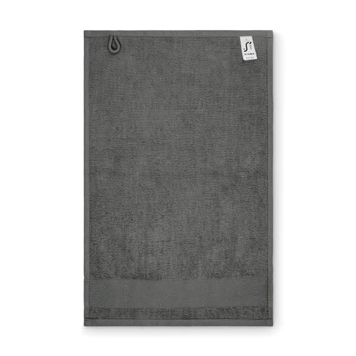 A grey towel featuring a loop for hanging and a small logo tag at the top.