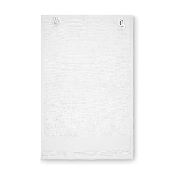 A white towel with a textured design, featuring a small logo in the corner.