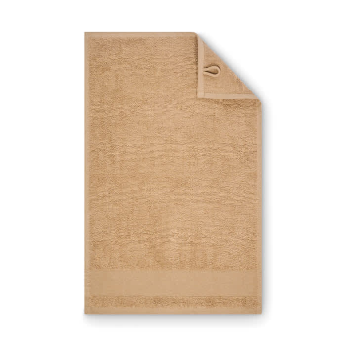 A bath towel in a warm beige colour, featuring a textured surface and a hanging loop on one corner.