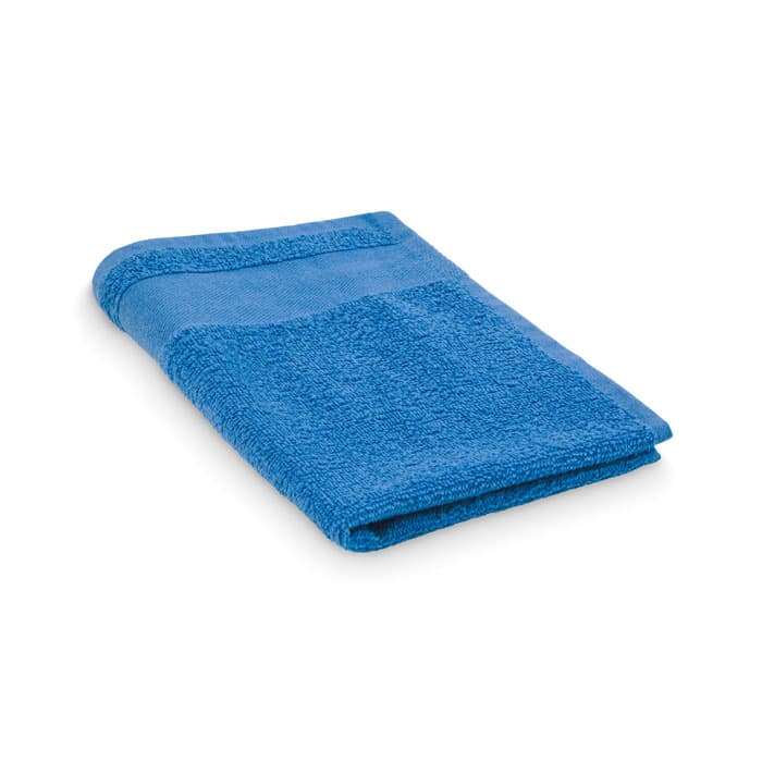 A blue bath towel folded neatly, featuring textured and smooth sections. The towel has a single decorative band.