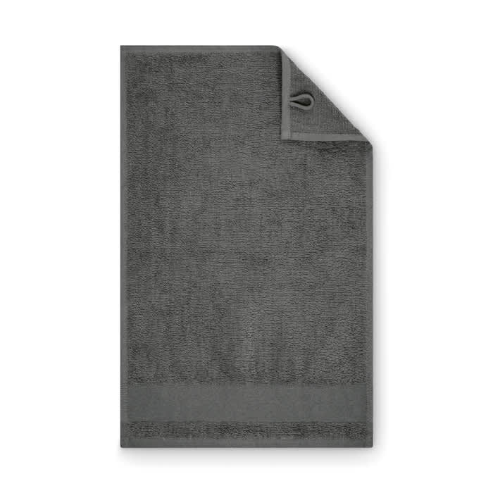A grey towel with a hanging loop, featuring a textured surface and a hemmed edge.