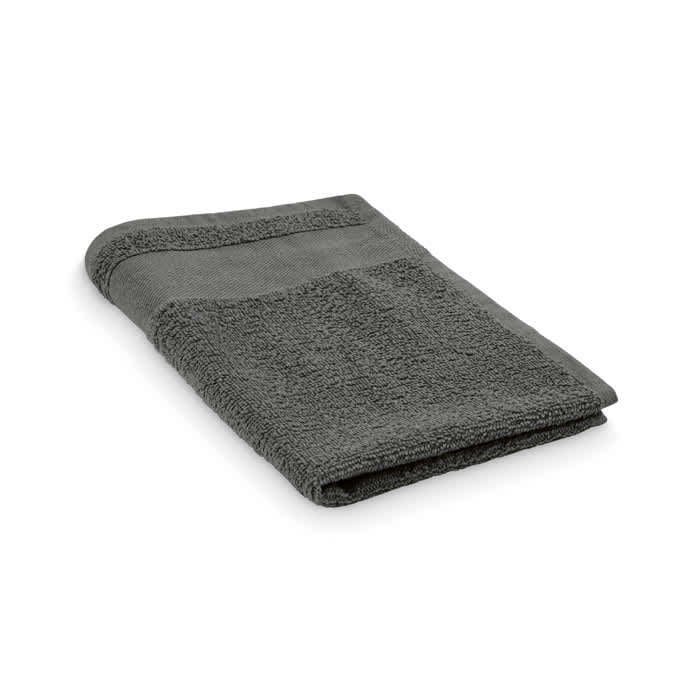 A grey towel, neatly folded, featuring a textured surface and a smooth edge. It has a simple design and appears soft.