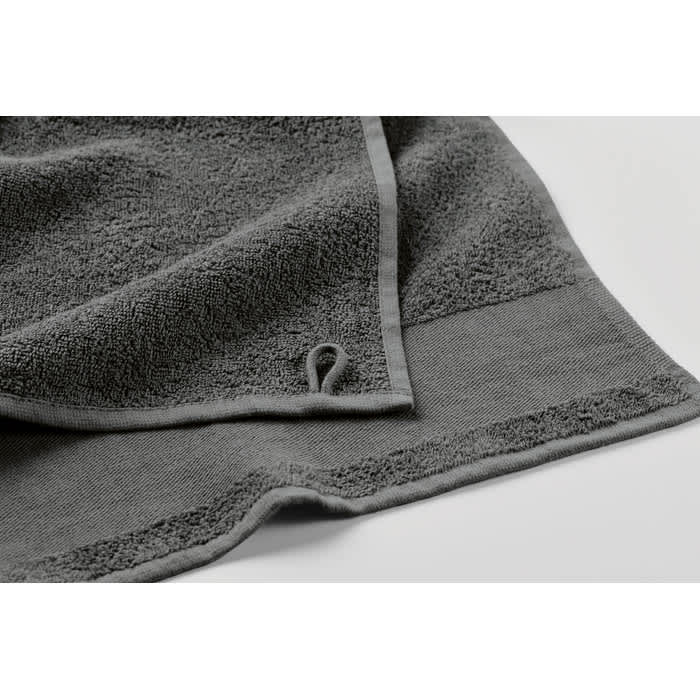 A grey towel with a textured surface and a loop for easy hanging. It features a soft, plush design.