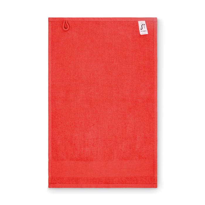 A coral red towel with a hook for hanging and a small branded label at the top.
