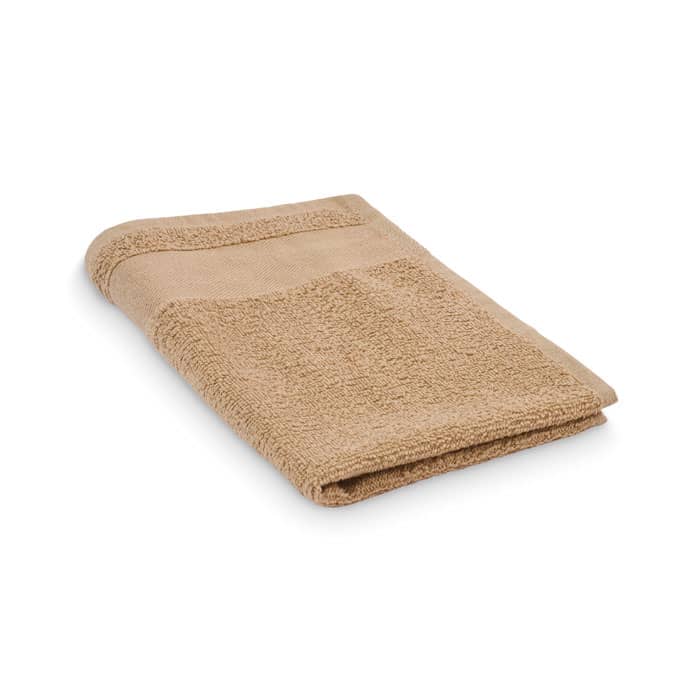 A folded beige towel with a textured surface and a smooth edge. It has a simple, minimalist design.