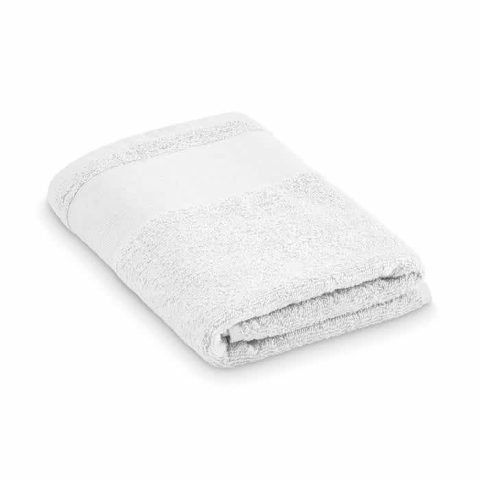 A folded white towel with a textured surface and a smooth band along one edge. It features no visible branding.