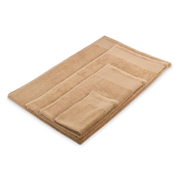 A set of beige towels arranged in a neat stack, featuring different sizes and a soft, plush texture.