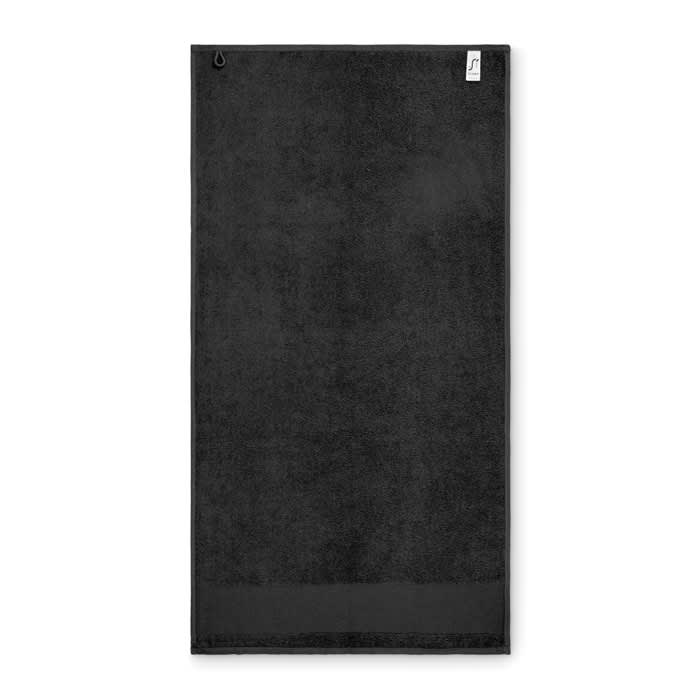 A black towel with a hanging loop and a textured fabric finish. It features a small logo on one corner.