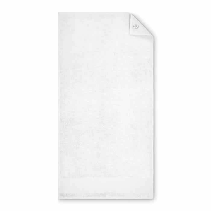 A white towel featuring a folded corner and a logo on one side.