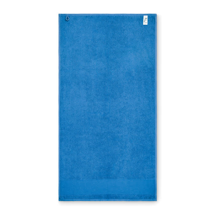 A blue towel featuring a hanging loop, designed for easy storage. It has a simple, solid colour design.