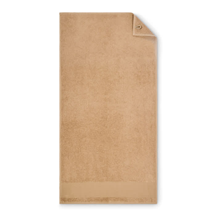A tan bath towel with a corner tag, featuring a soft, plush texture and a simple, elegant design.