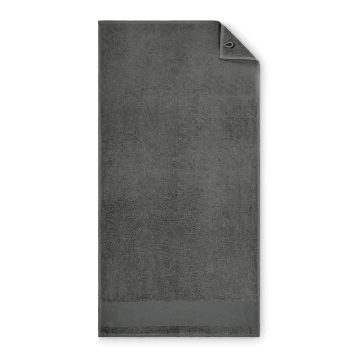 A grey towel with a folded corner and a loop for hanging. The surface appears soft and plush.