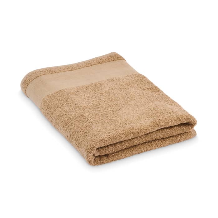 A folded towel in a soft beige colour with a smooth edge, featuring a textured surface.