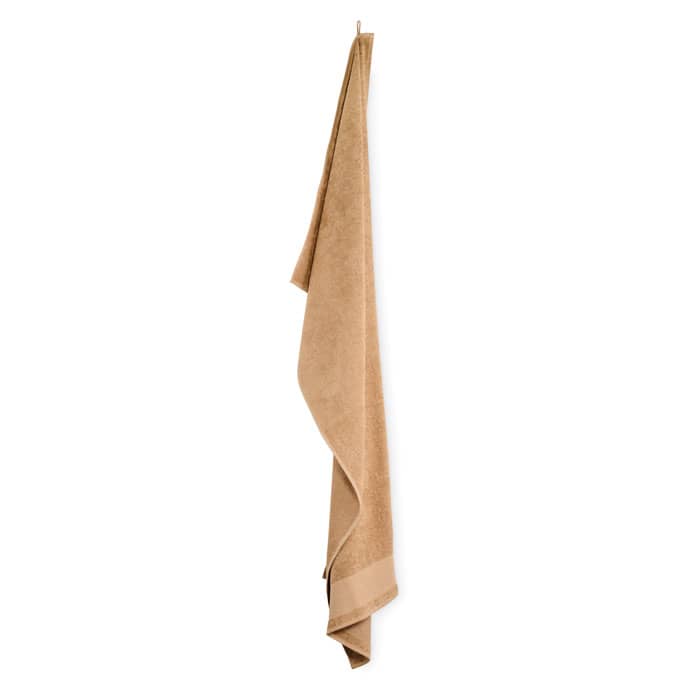A beige towel hanging vertically, with a textured finish and a bordered edge.