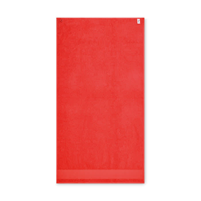 A red towel featuring a subtle texture, with a small logo at the top.