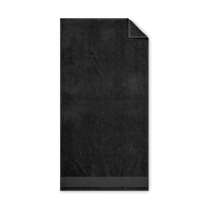 A black towel with a smooth texture and a folded corner, featuring a simple design without any logos.