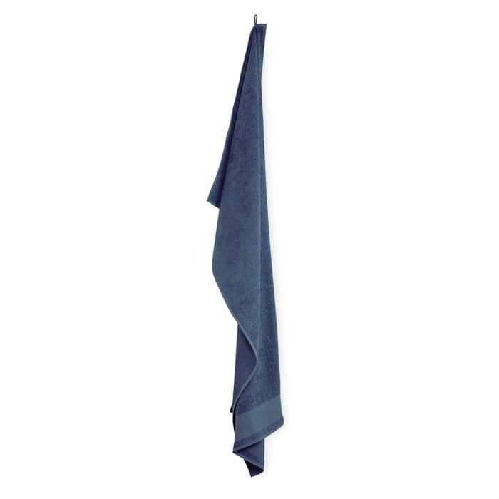 A navy blue towel hanging vertically, featuring a simple design and a soft texture. It has branding on it.