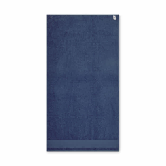 A navy blue towel with a textured surface, featuring a small branding label at the top.