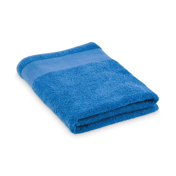 A folded blue bath towel featuring a textured and smooth section. It has a simple design and is soft to the touch.