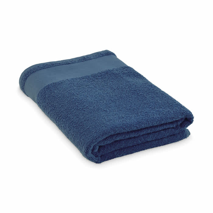 A folded navy blue towel with a contrasting band across the centre, showcasing a soft texture. It features a logo.