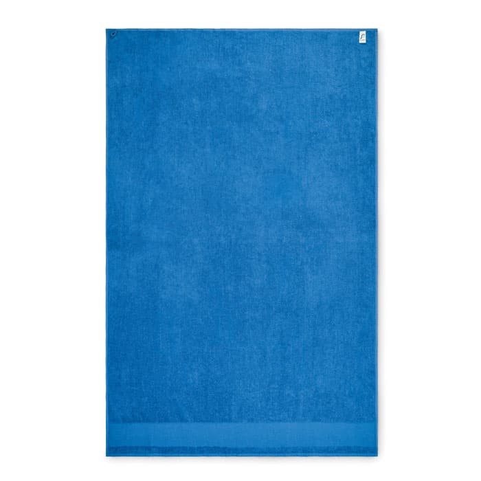 A blue beach towel with a textured finish and hanging loop, featuring a logo in one corner.