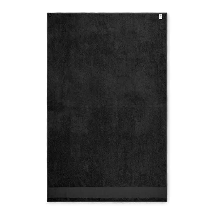 A black bath towel with a textured surface, featuring a small logo in one corner.