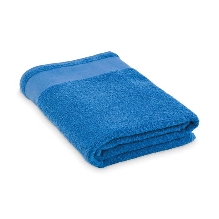A blue towel neatly folded, featuring a contrasting blue band along one edge. The towel has a soft texture.