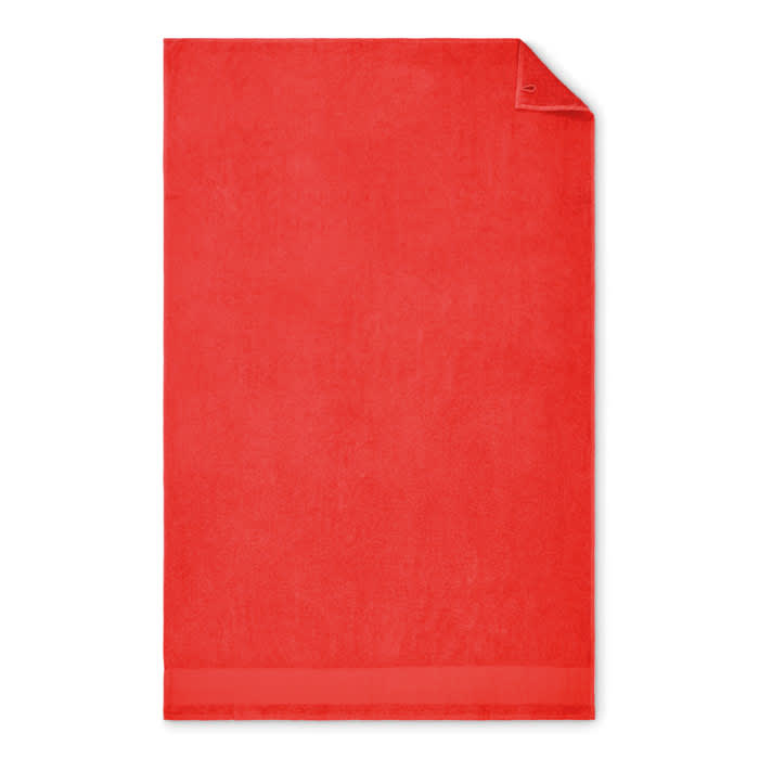 A red bath towel with a soft texture and a simple design, featuring a folded corner. It has no visible branding.