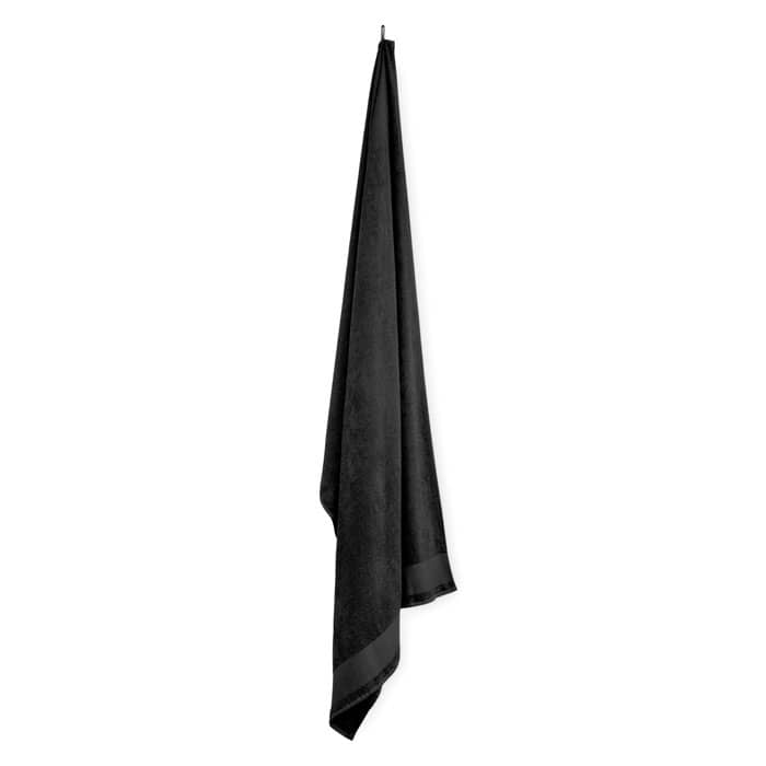 A black towel hangs vertically, featuring a smooth texture and a simple design without any visible branding.