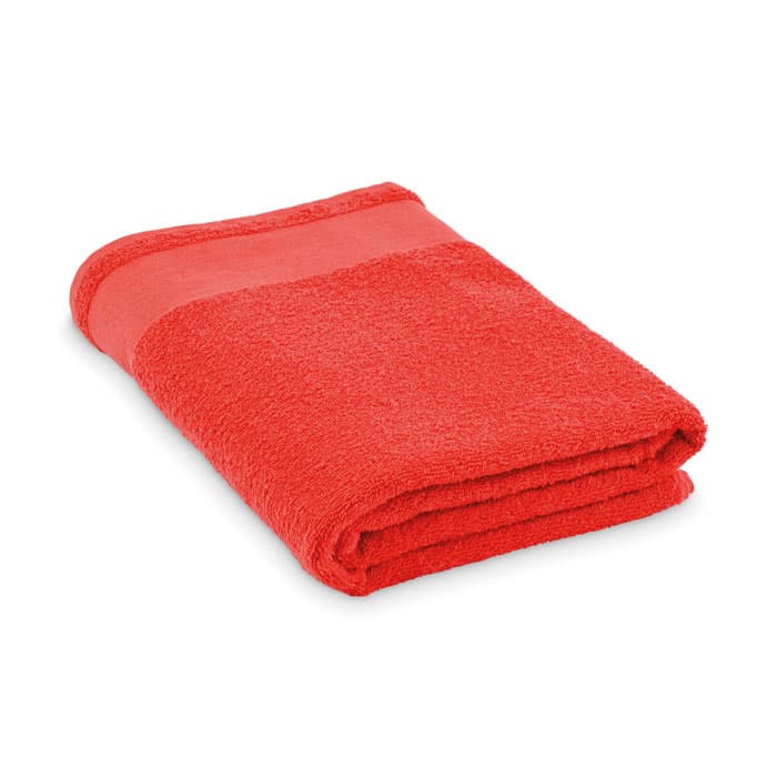 A folded red towel with a contrasting band, showcasing a soft and plush texture.