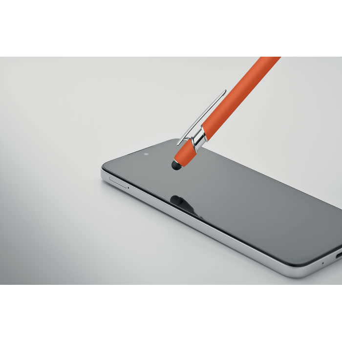 An orange pen rests on a sleek, black smartphone screen, alongside a minimalist backdrop.