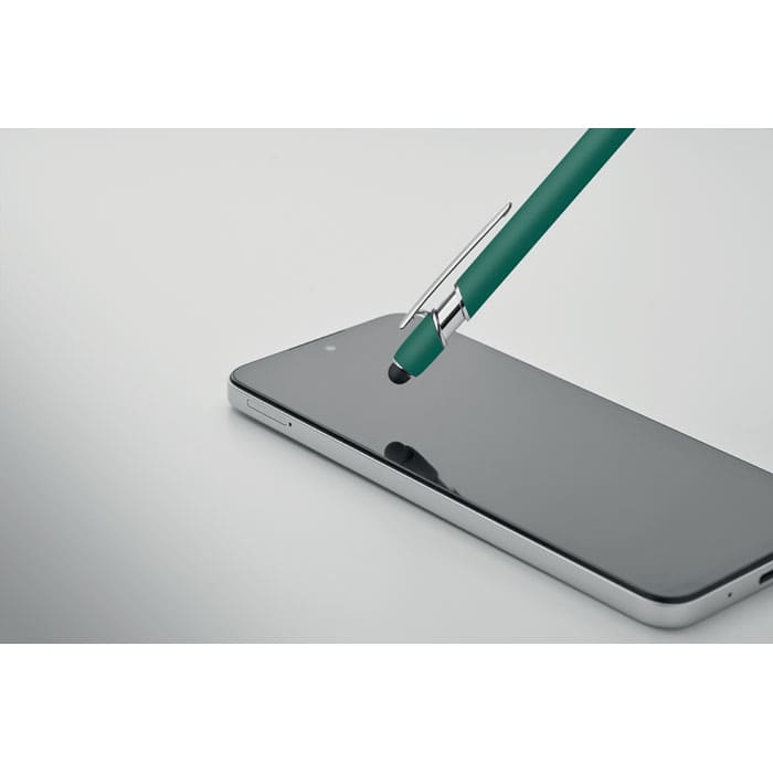A green pen resting on a sleek, reflective smartphone screen. The smartphone has a silver edge.