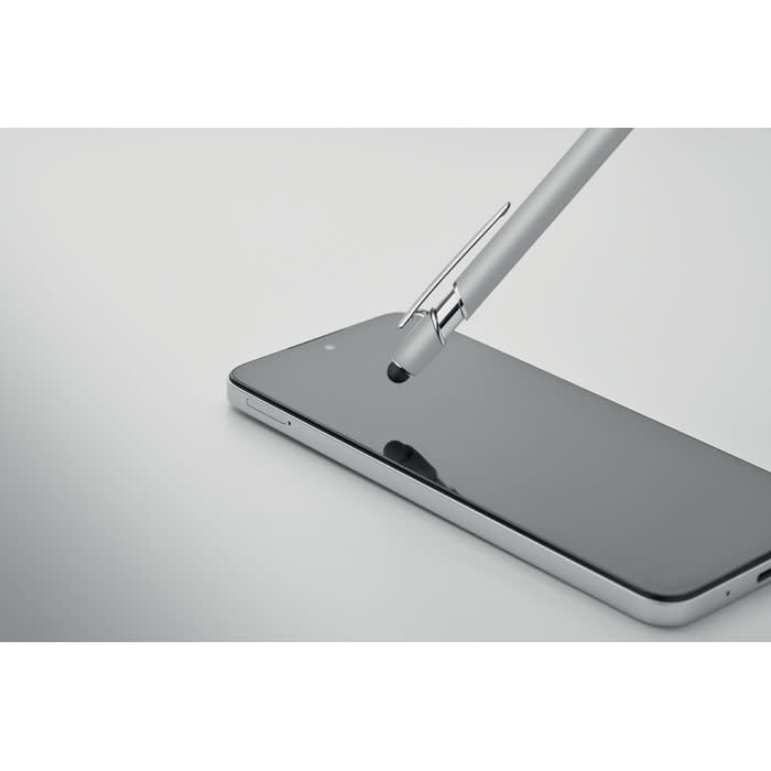 A smartphone with a reflective screen and a silver pen resting on it, highlighting the device's sleek design.